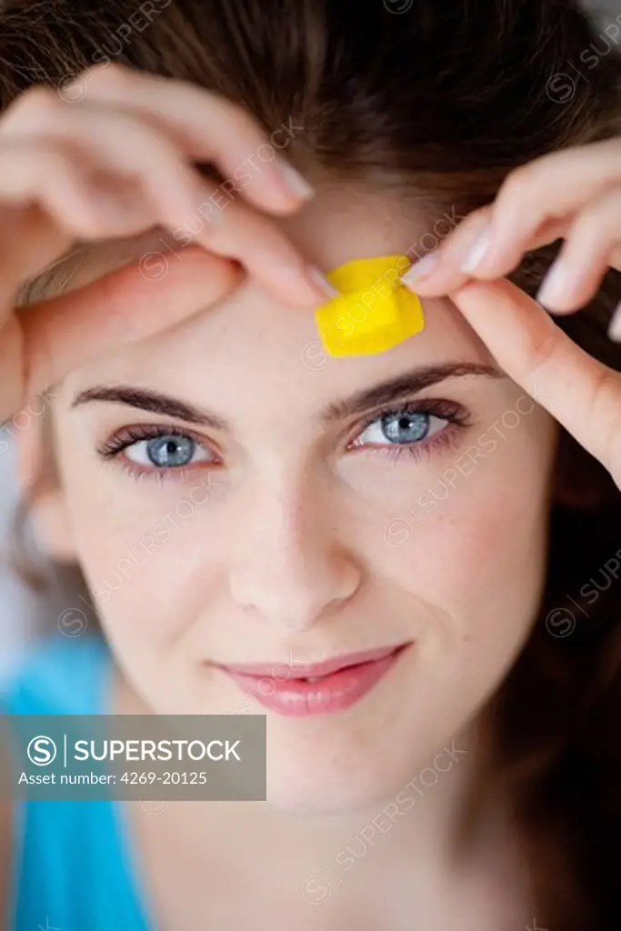 Woman putting a band-aid on Forehead.