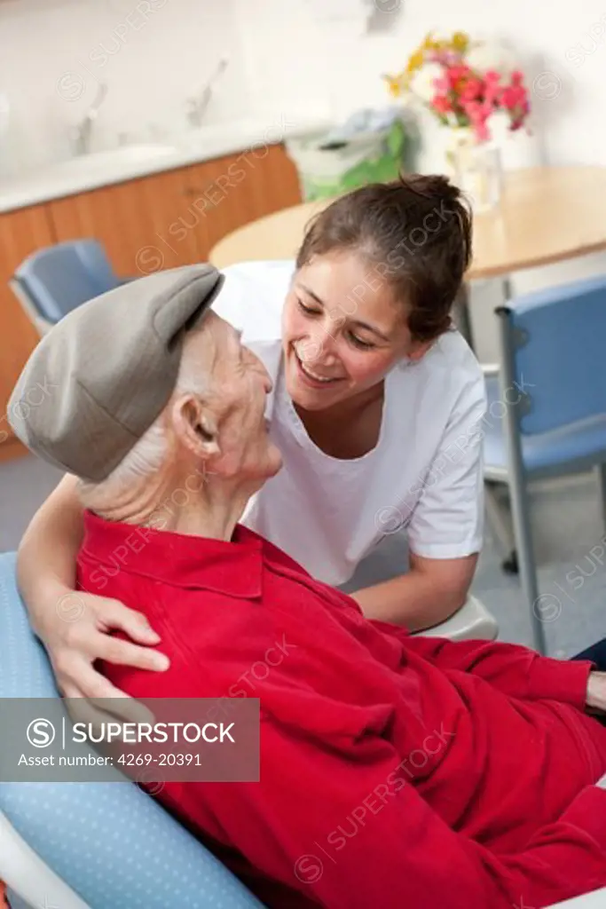 Auxiliary nurse talking with centenarian person. Residential home for dependent elderly person, Limoges, France.