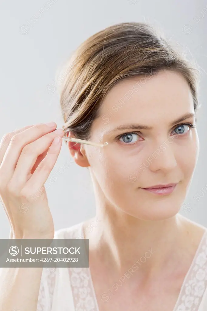 Woman using serum eye contour.