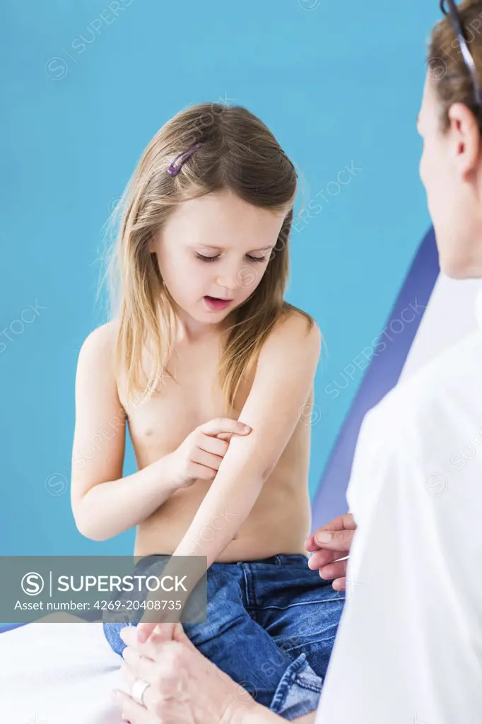 Pediatrician examining the skin of a 4 year old girl.