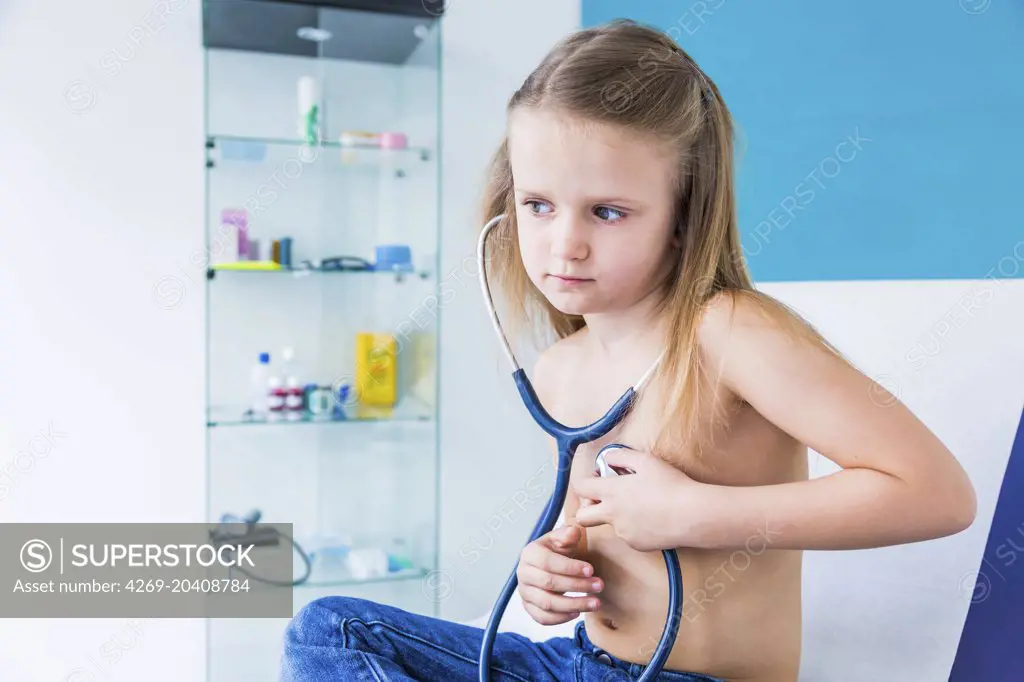 Girl using a stethoscope to listen to her chest.