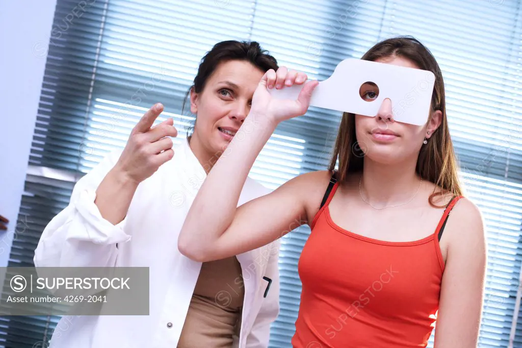 Female teenager passing a sight examination during medical consultation.
