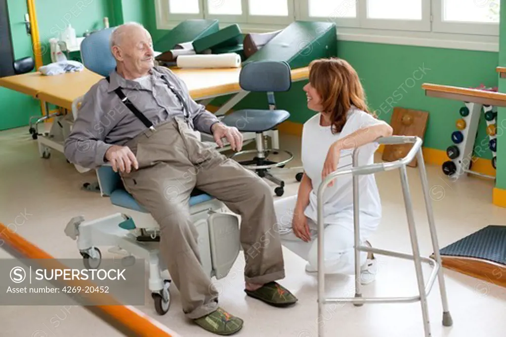 Elderly man in functional reeducation session with a physiotherapist after the break a hip. Residential home for dependent elderly person, Limoges, France.
