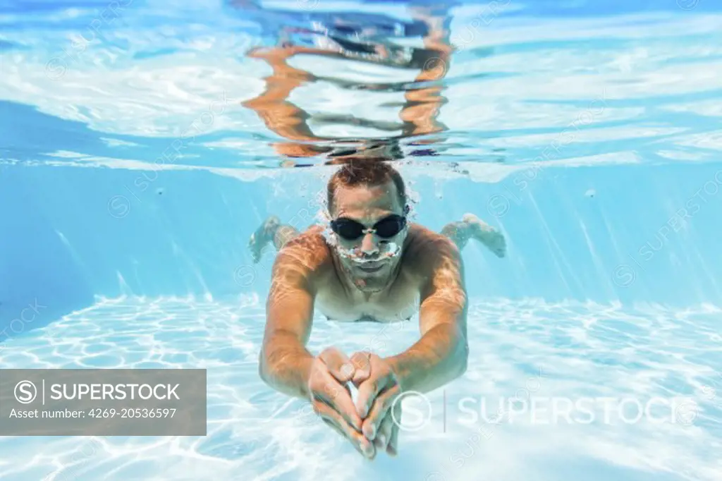 Man swimming in swimming pool.