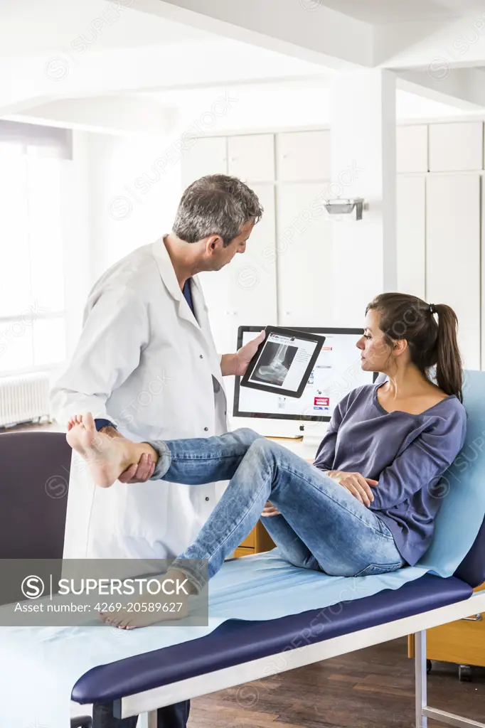 Doctor examining the ankle of a female patient.