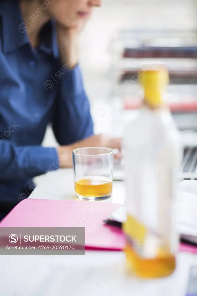 Office worker drinking alcool.