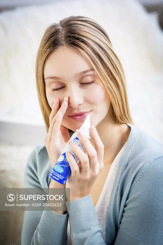 Woman using a sterile sea water spray.