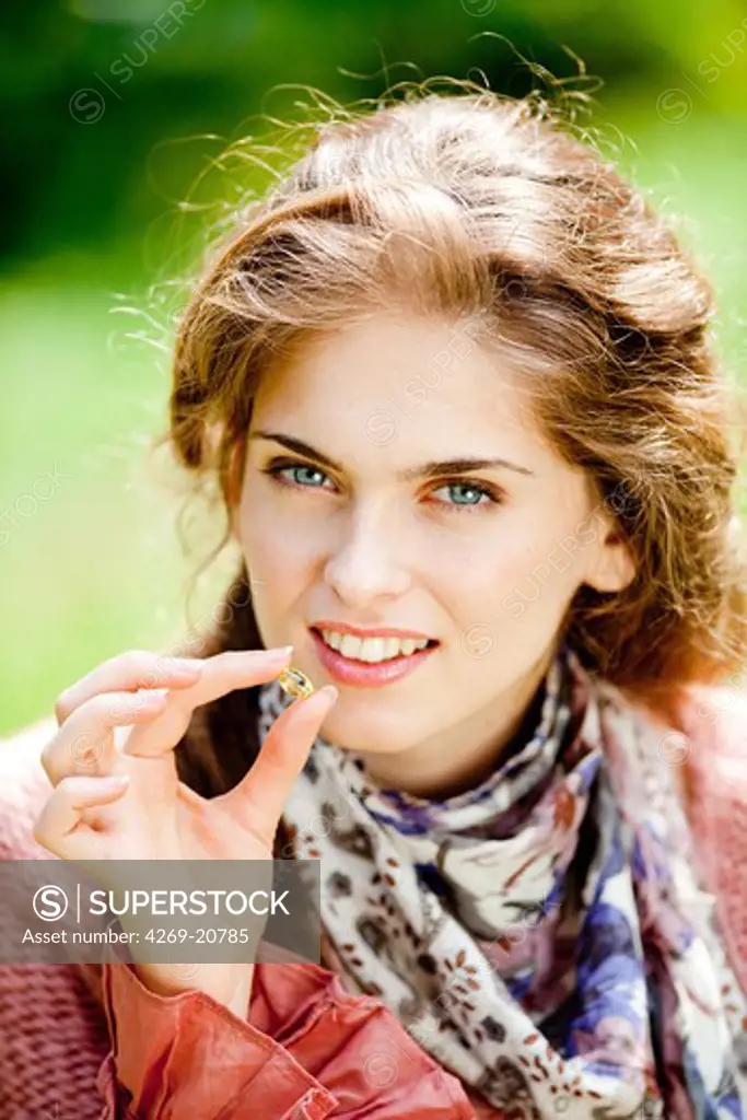 Woman taking food supplement capsules.