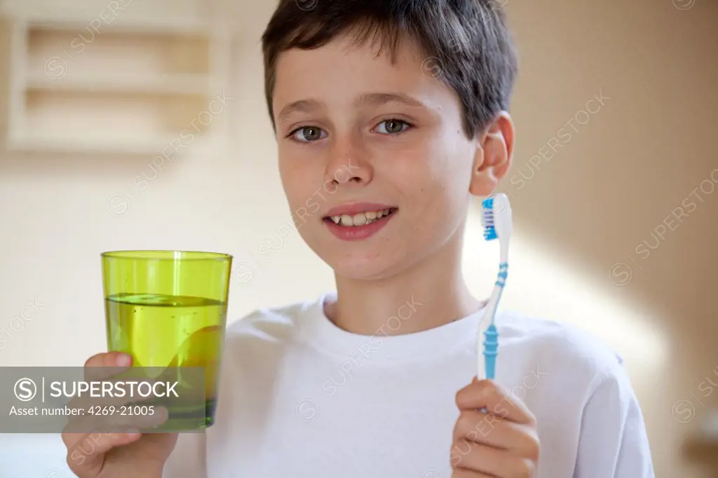 10 years old boy brushing his teeth.