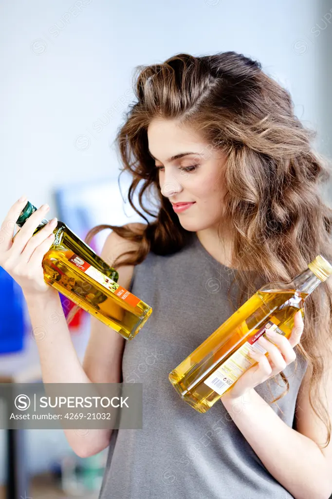 Woman holding oil bottles.