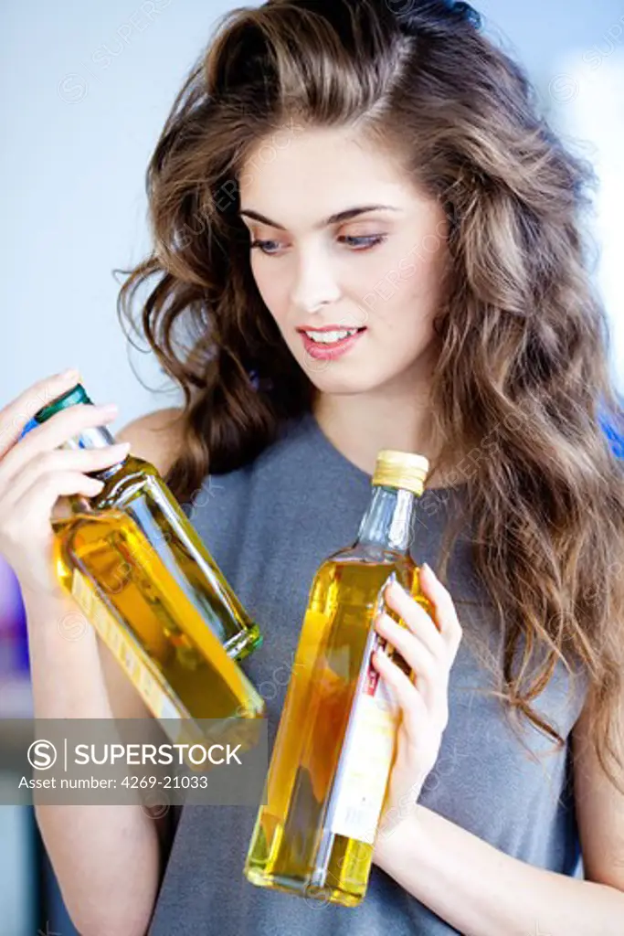 Woman holding oil bottles.