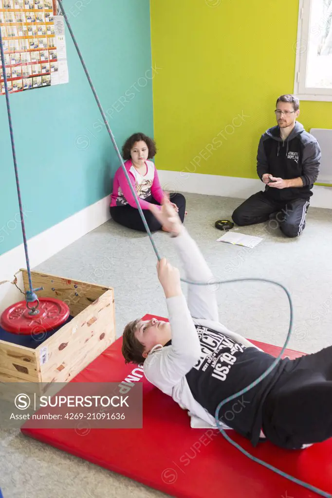 Obesity care and treatment center for children and teenagers , "Les Terrasses", Niort France. Here a sport instructor assesses the ability of patients to physical and sports activities . A sports teacher establishes the program of physical activity and sport for the young patients.