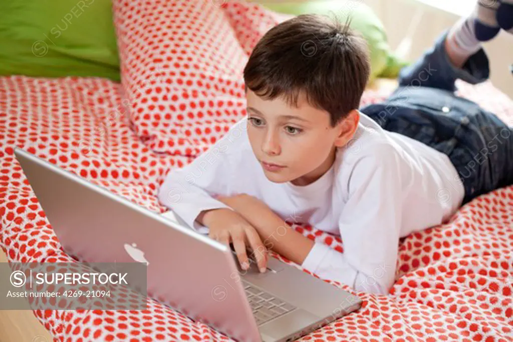 10 years old boy using laptop computer.