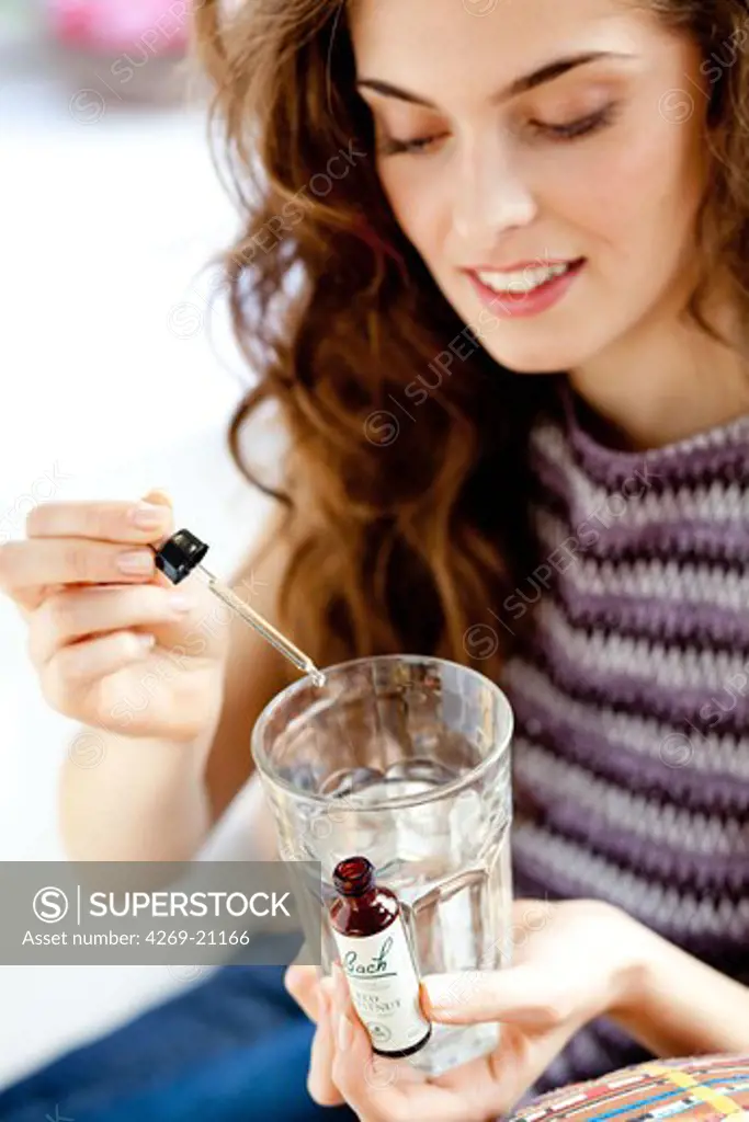 Woman using a Bach remedy (liquid flower extract).