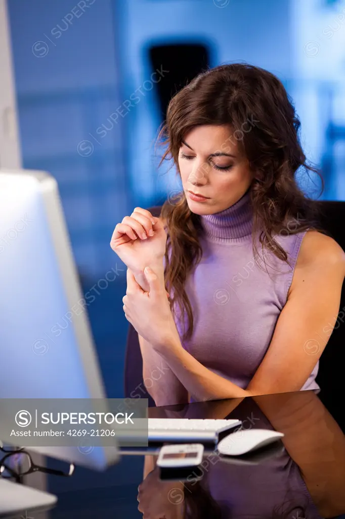Woman at work suffering from wrist pain.