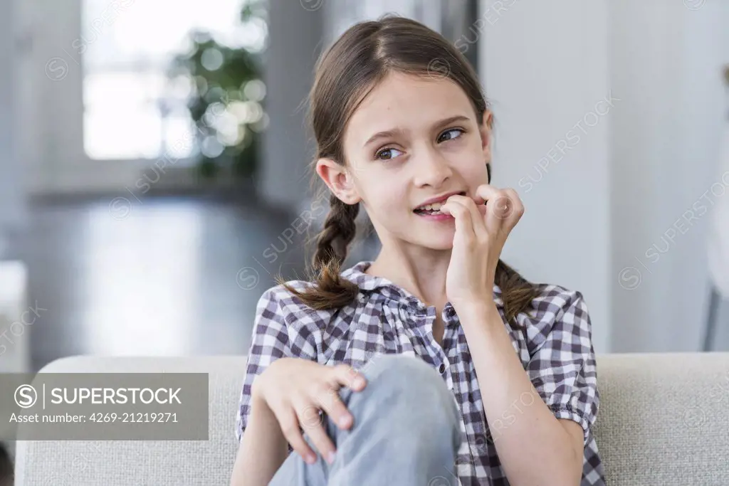 9 year-old girl bitting her nails.
