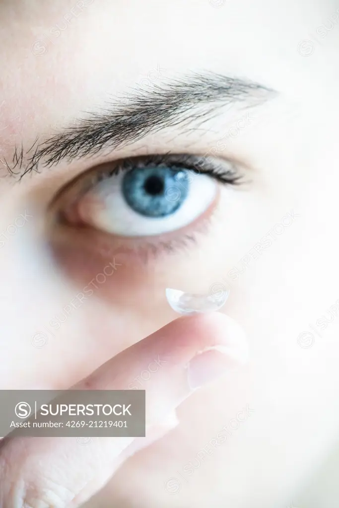 Woman putting in a contact lens.
