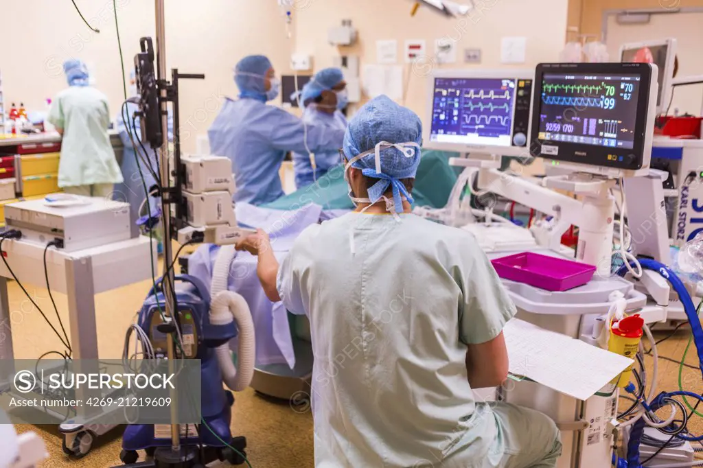 Surgical monitors being used to track the vital signs of a patient during an operation, Limoges hospital, France.