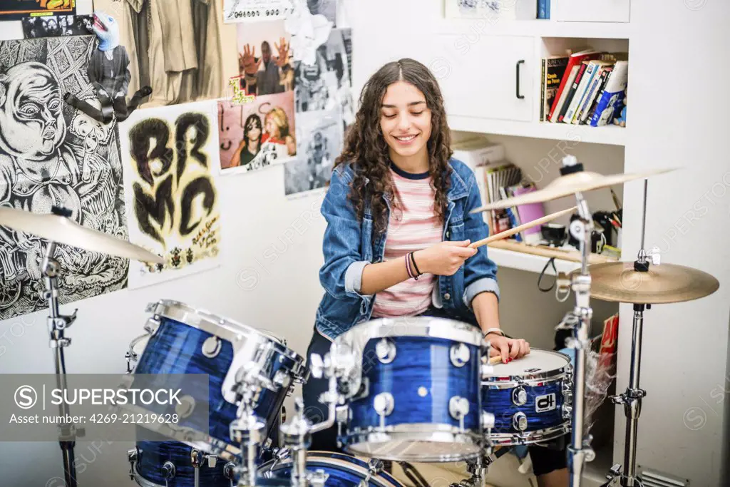 Teenage girl playing drums.
