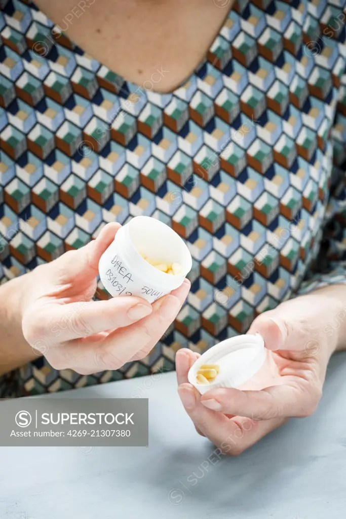 Woman taking DHEA capsules.