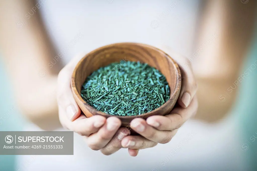 Woman taking food supplement of spirulina algae.