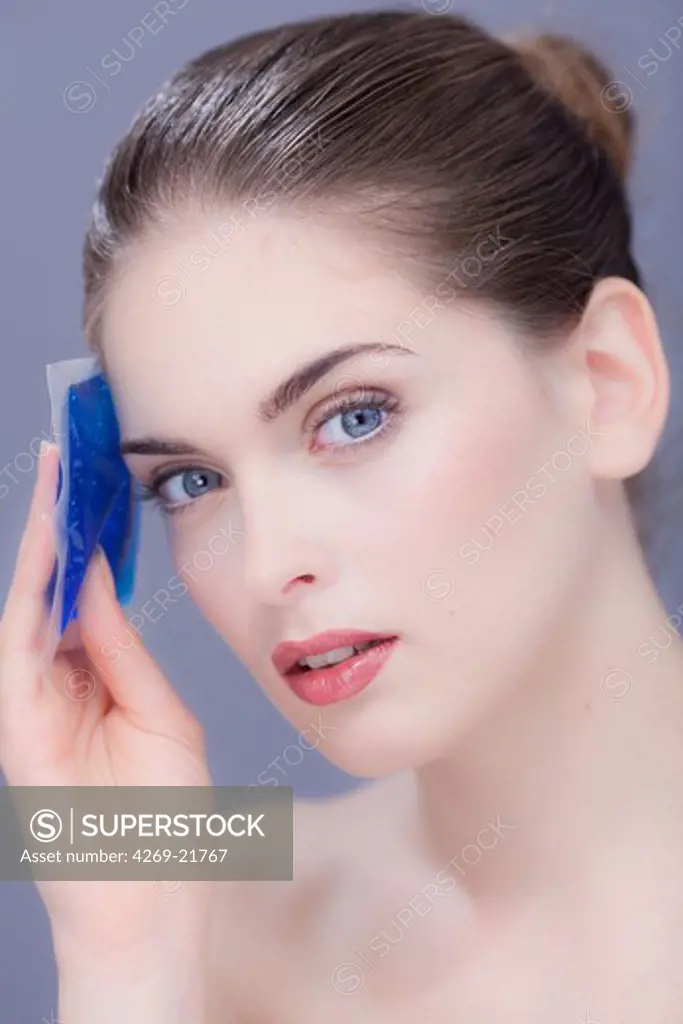 Woman using a hot-cold gel pack treatment to releive pain.