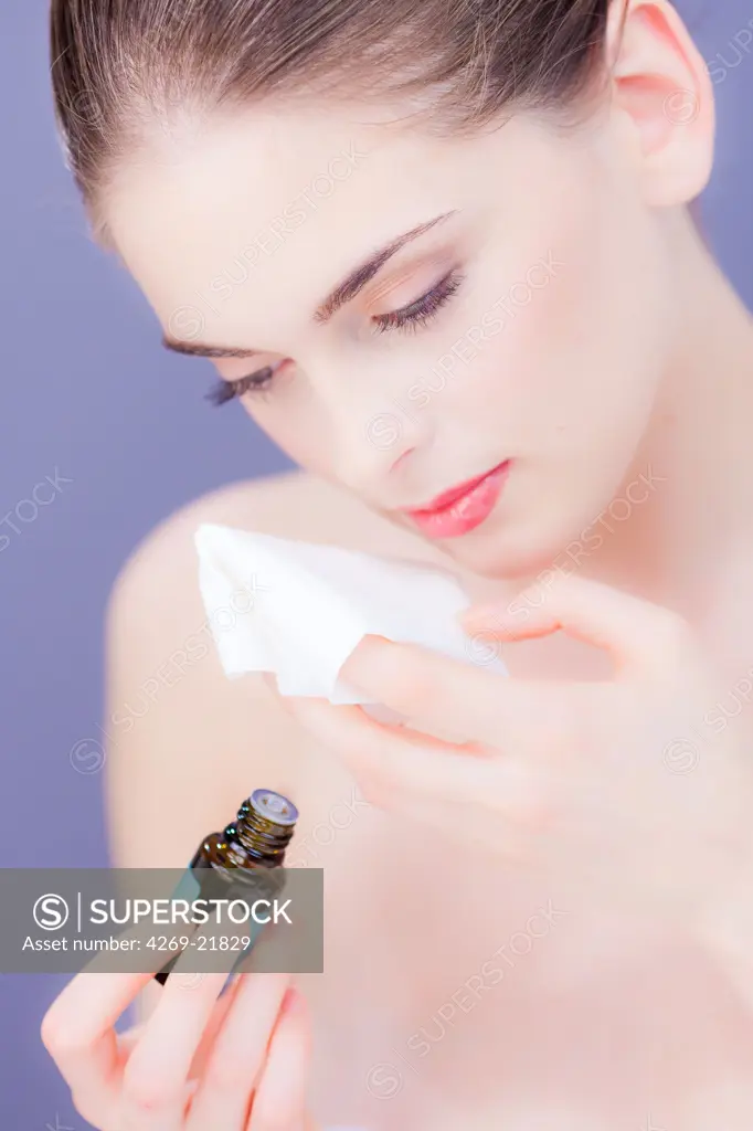 Woman smelling essential oil.