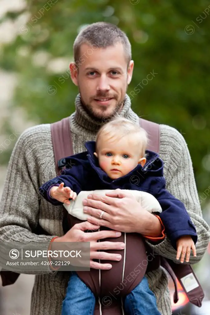 Father carrying 10 months baby girl.