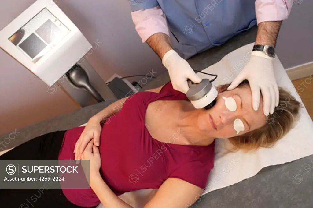 Woman undergoing a skin treatment with Lumisculpt. The Lumisculpt generates pulsed light, used to treat pigmentary moles (naevus), wrinkles and hair distribution. Before treatment, an electronic camera measures the caracteristics of the skin.
