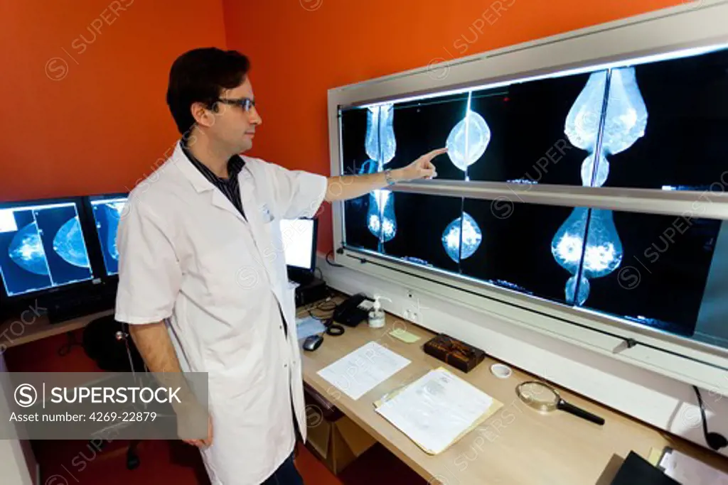 Radiologist examining Senobright contrast-enhanced digital mammography. This new technology developed by GE Healthcare provides contrasting image to highlight potential areas of angiogenesis. Armentieres hospital, France.