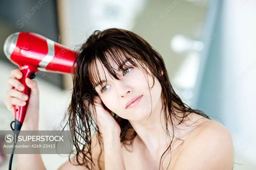 Woman using hair dryer.