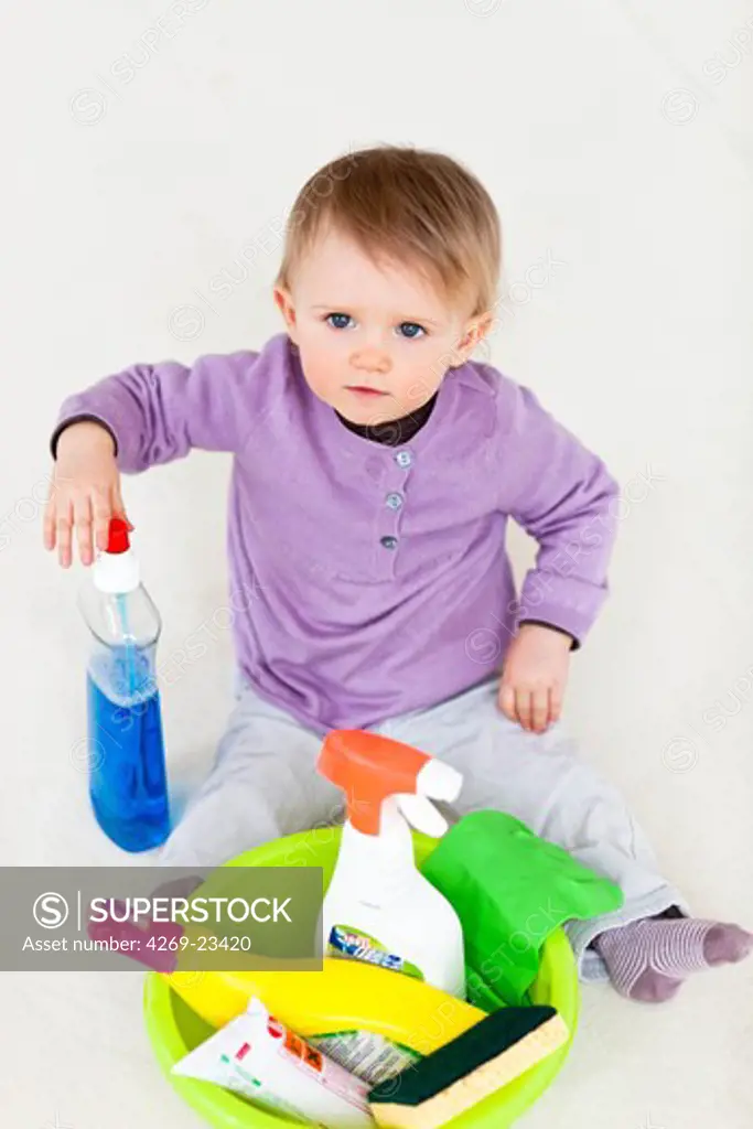 13 months old baby girl playing with household cleaning products : poisoning hazard.