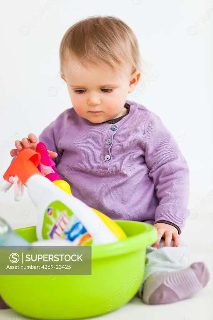 13 months old baby girl playing with household cleaning products : poisoning hazard.