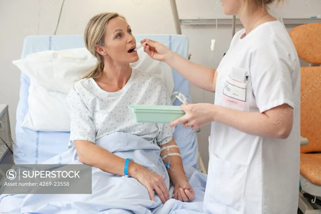 Nurse giving medication to a patient at hospital. Limoges hospital.