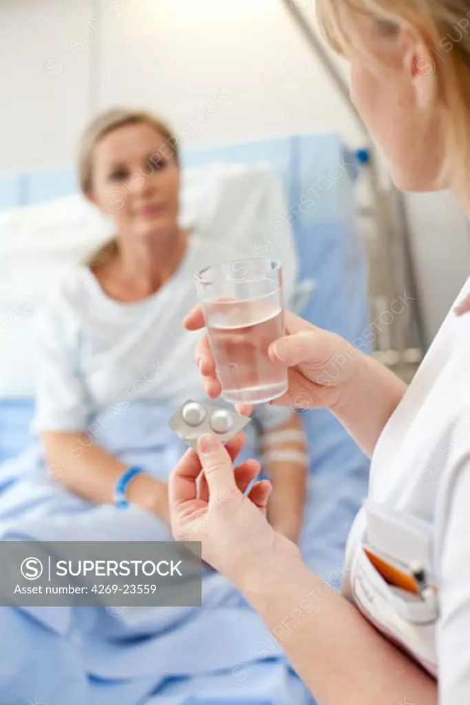 Nurse giving medication to a patient at hospital. Limoges hospital.