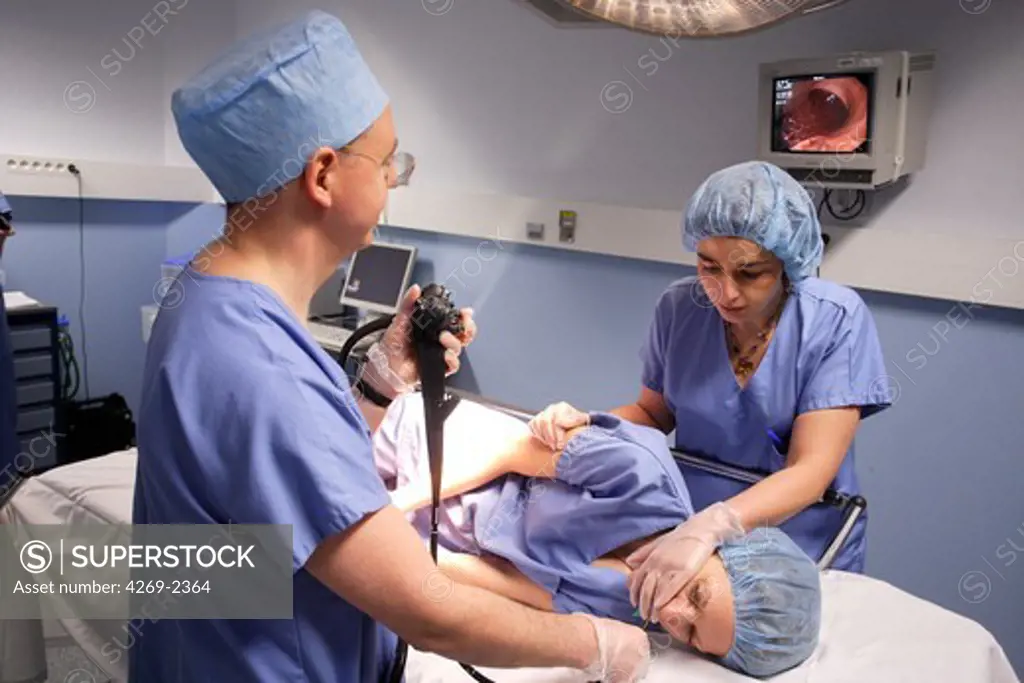 Gastroenterologist performing a gastrointestinal fiberoptic endoscopy. A flexible fibre-optic endoscope is introduced through the mouth and navigates inside the digestive tract.