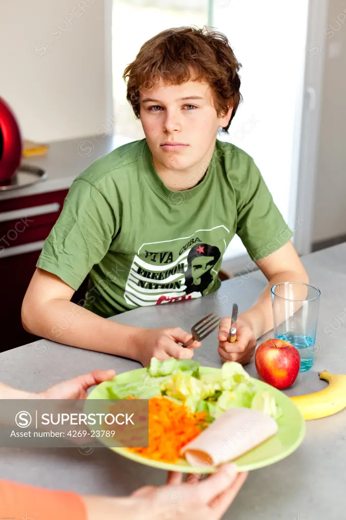 Teenager eating salad.