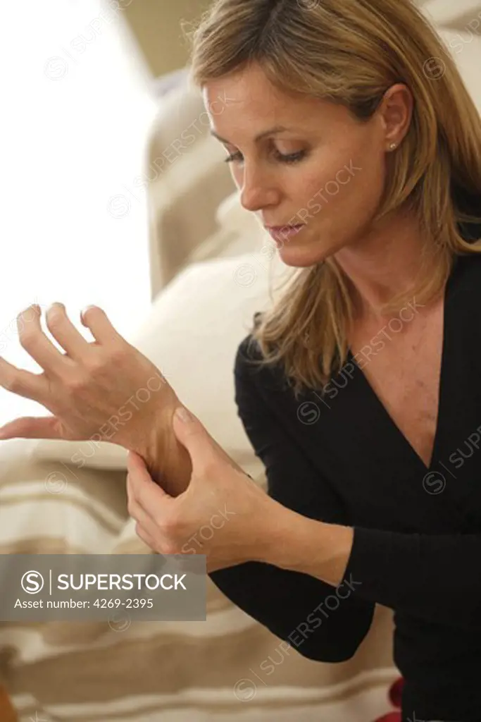 Woman suffering from an articular pain in the wrist.