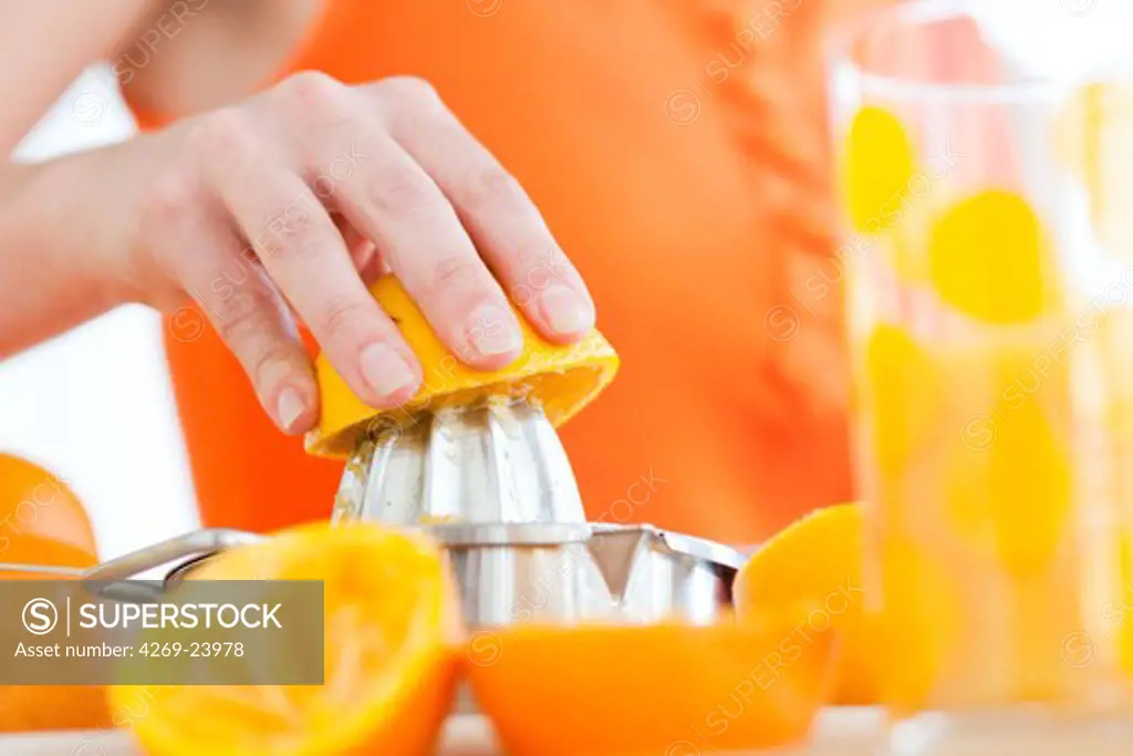 Woman squeezing oranges.