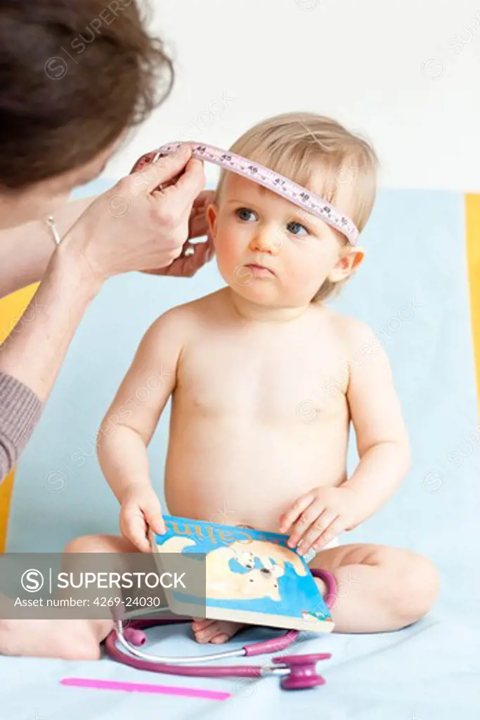 Measurement of the circumference of a 14 months old baby's head (cranial perimeter) with a tape measure.