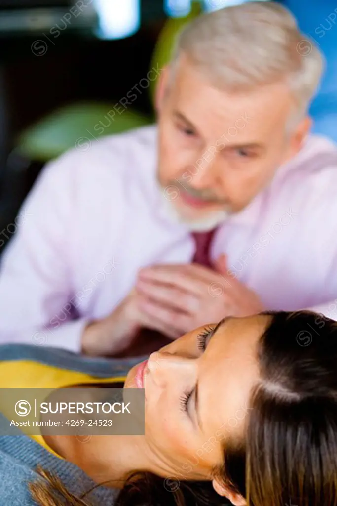 Woman undergoing hypnosis cession with a sophrologist.