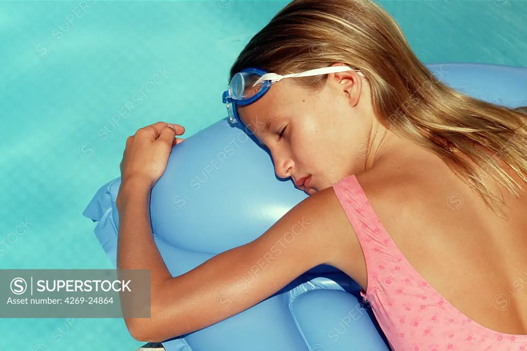 Sun. 10 years old girl enjoying a sun bath atthe swimmming pool.