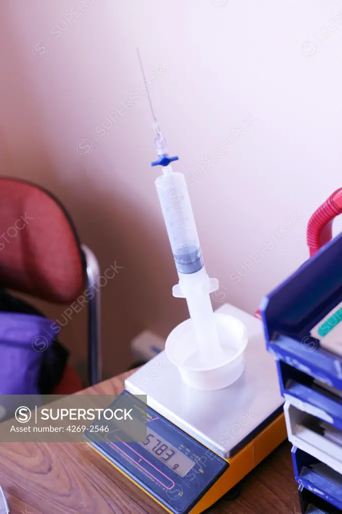 Department of Endocrinology of the Pr Jacques Bringer, hospital Lapeyronie, University hospital of Montpellier, France. A syringe containing insuline is weighted before filling an insulin pump.