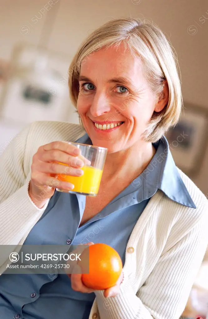 Senior. Woman drinking orange juice.