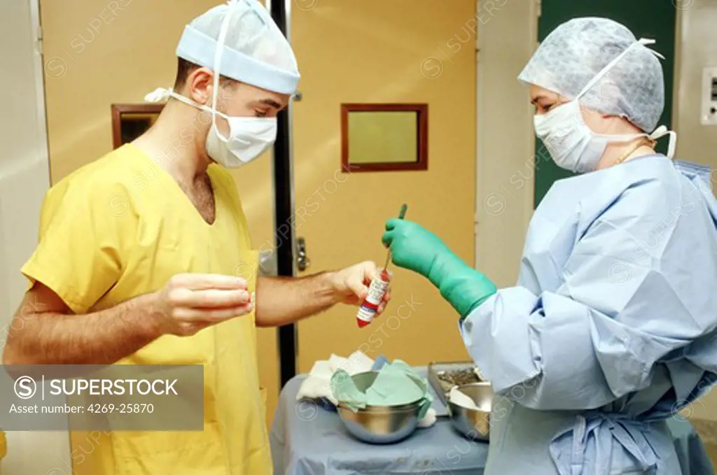 Third-degree burnt person. Burn victims care center. Hospital staff extracts skin tissue for derm culture, prior to human skin transplant.  Third-degree burnt person