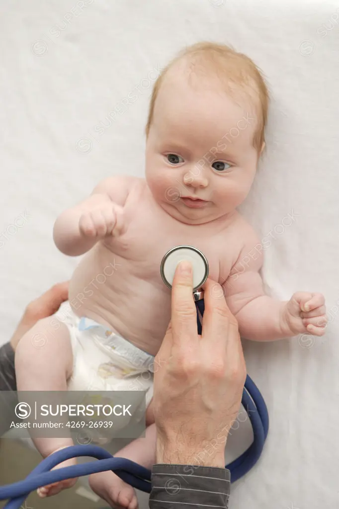 Pediatric consultation. A pediatrician examines a 2 months old baby with an stethoscope.