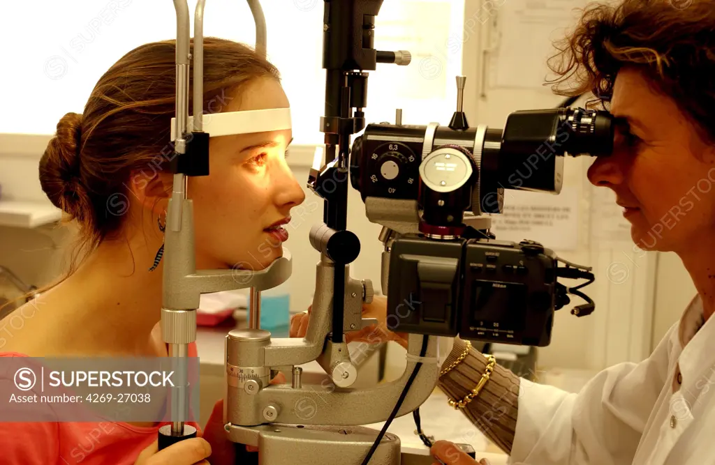 Ophthalmology. Ophthalmologist carrying out an examination opthtalmologic using a slit-lamp. This instrument shines a fine beam of light into the eye, and magnifying lenses allow the optician to explore the spot where the beam falls.