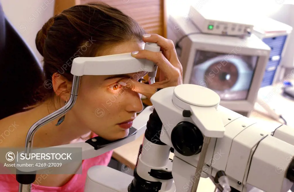 Ophthalmology. Ophthalmologist carrying out an examination opthtalmologic using a slit-lamp. This instrument shines a fine beam of light into the eye, and magnifying lenses allow the optician to explore the spot where the beam falls.