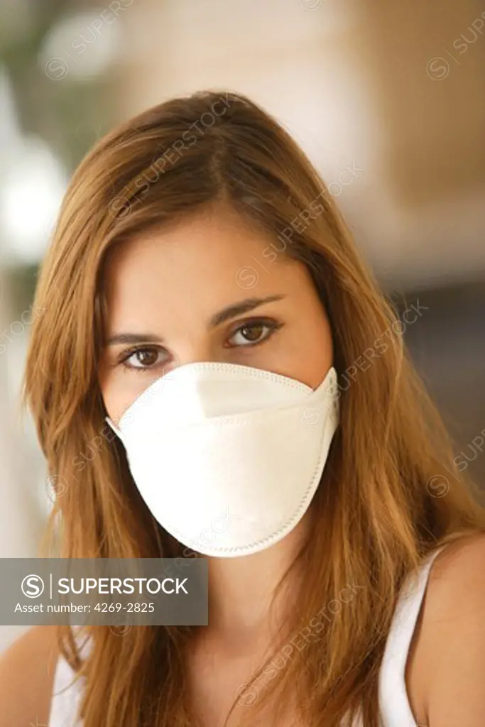 Woman wearing a protective breathing mask FFP2 (in conformity with the standard EN149:2001). It is recommended to wear this mask in case of flu pandemic.