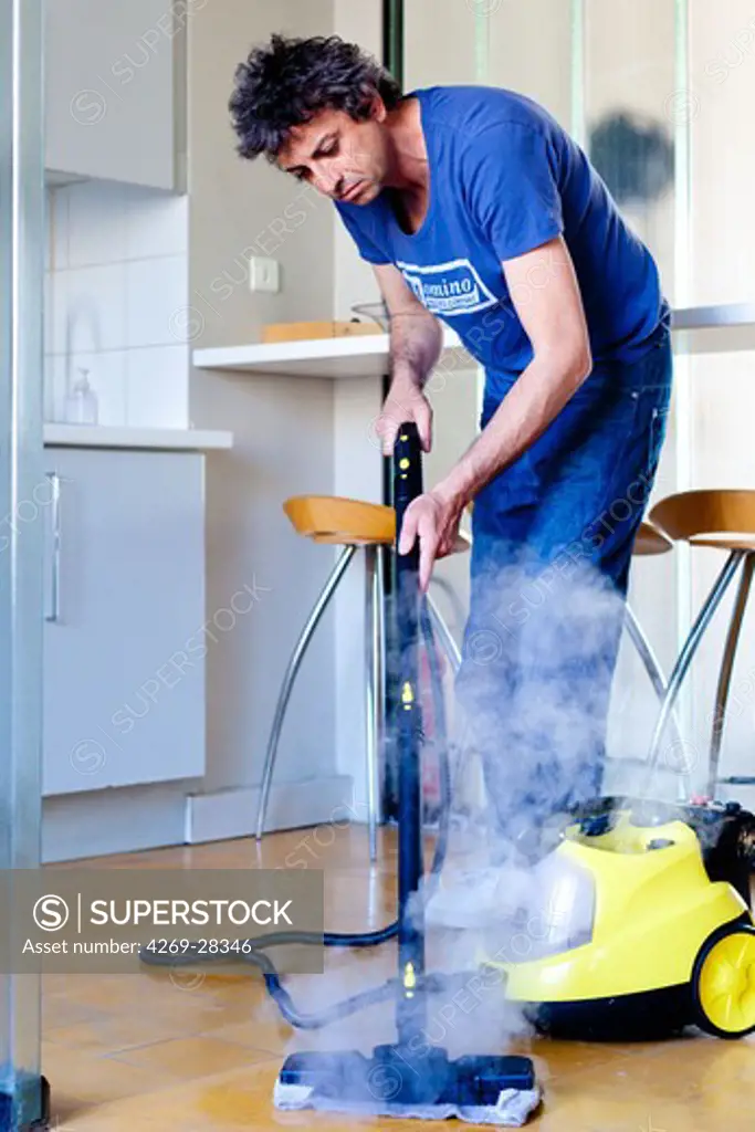 Man using a steam cleaner.